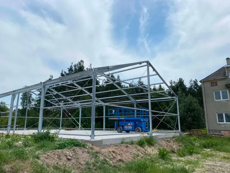 Konstrukcja stalowa hali na płycie fundamentowej — słupy, ramy i stężenia krzyżowe przed poszyciem
